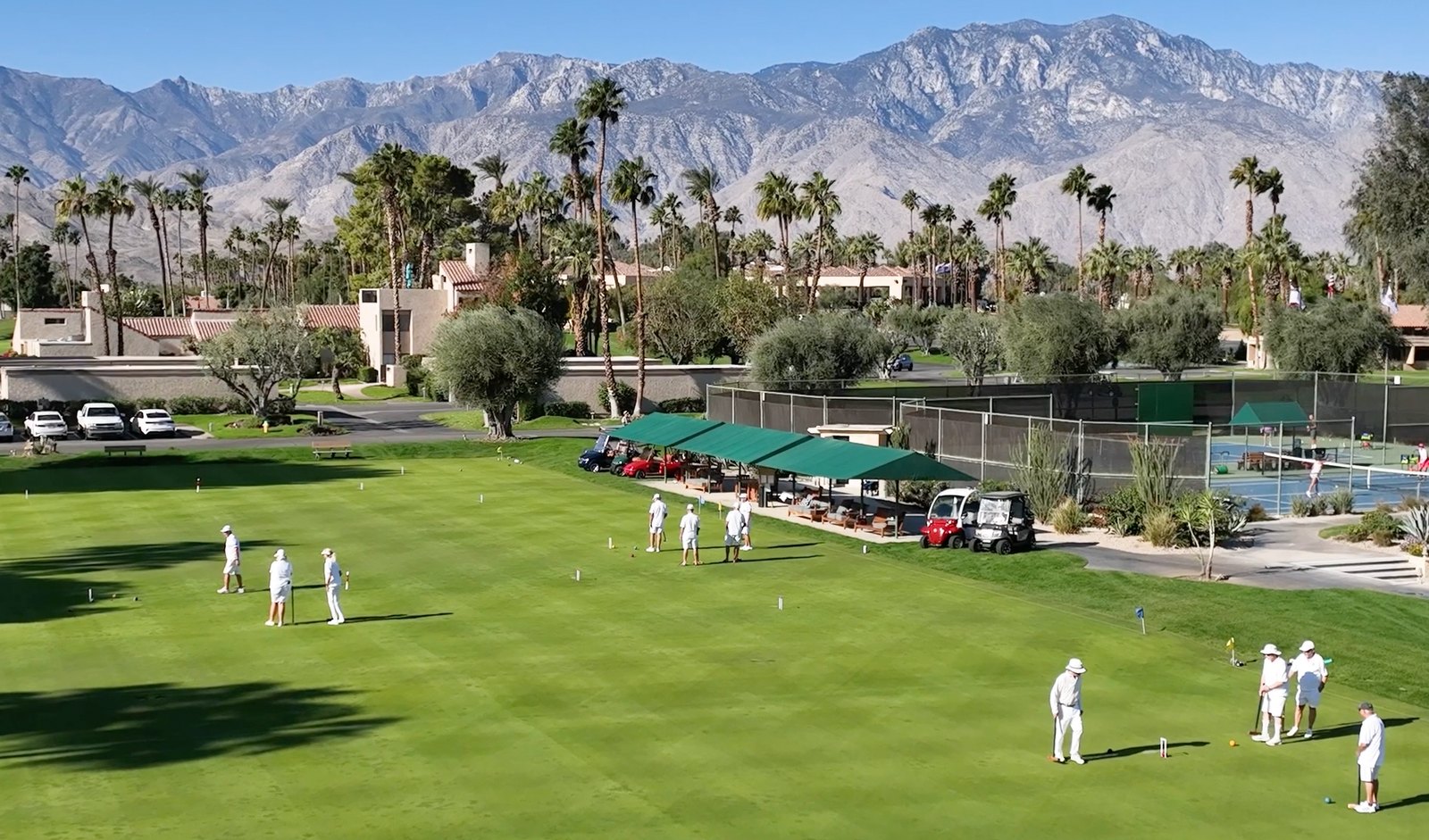 Aerial view of the croquet lawn at Mission Hills Country Club, with players in whites and the Santa Rosa Mountains beyond