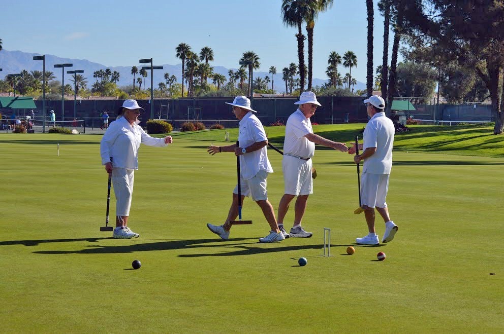Members in whites shaking hands after a game on the lawn