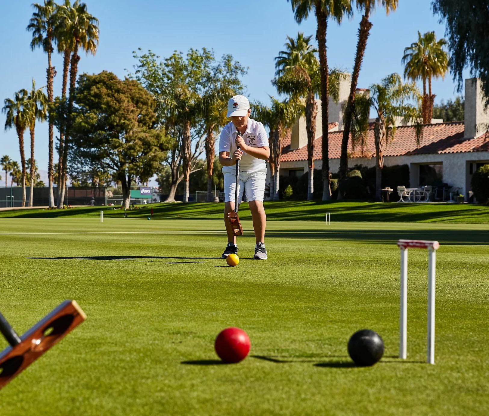A member mid-swing beneath the palms
